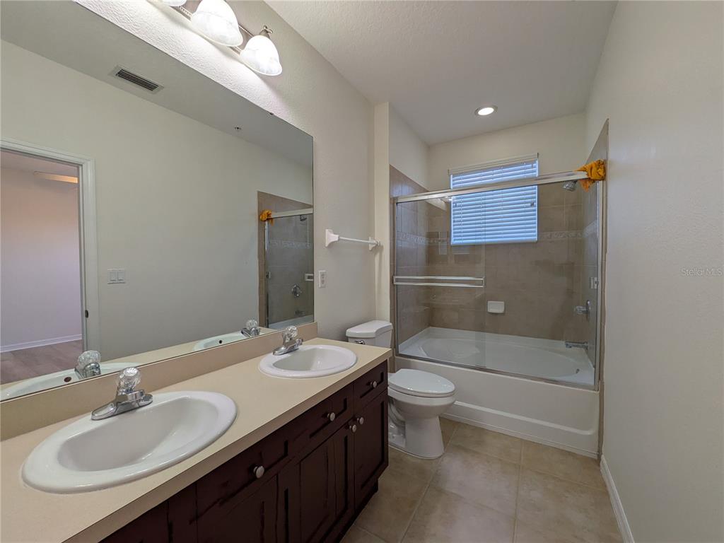 11562 Amidship Lane, Unit 208 Windermere, FL 34786 - Photo 26 of 31 a bathroom with a double vanity sink toilet mirror and shower