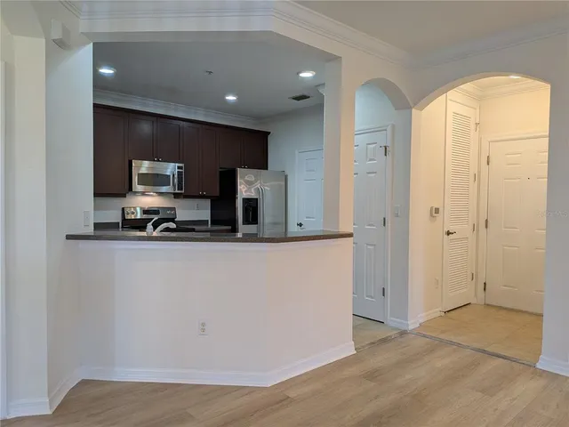 a kitchen with granite countertop a refrigerator and a stove top oven