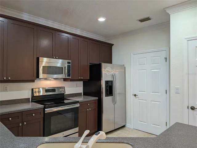 a kitchen with stainless steel appliances granite countertop a refrigerator and a stove top oven