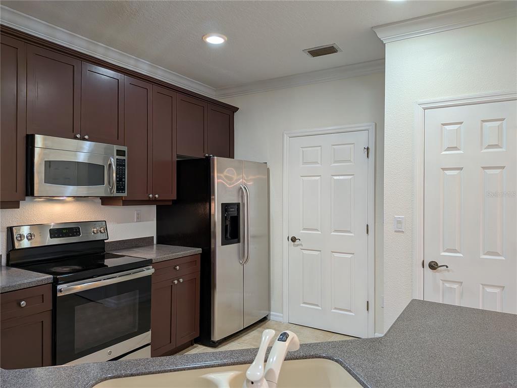 11562 Amidship Lane, Unit 208 Windermere, FL 34786 - Photo 10 of 31 a kitchen with stainless steel appliances granite countertop a refrigerator and a stove top oven