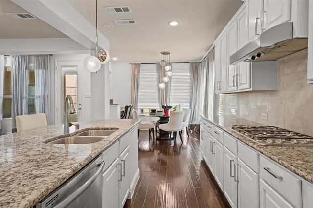 a kitchen with granite countertop a sink stove and cabinets