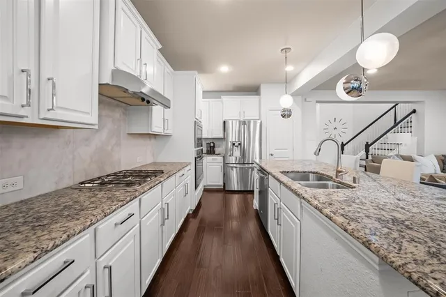 a large kitchen with granite countertop a sink and stove