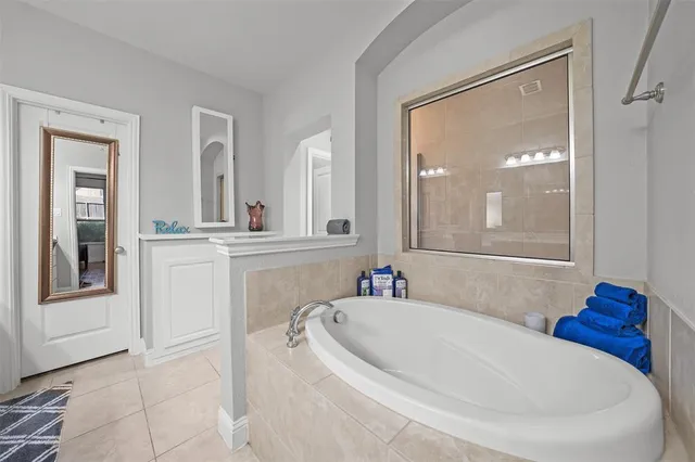 a bathroom with sink and mirror with bathtub