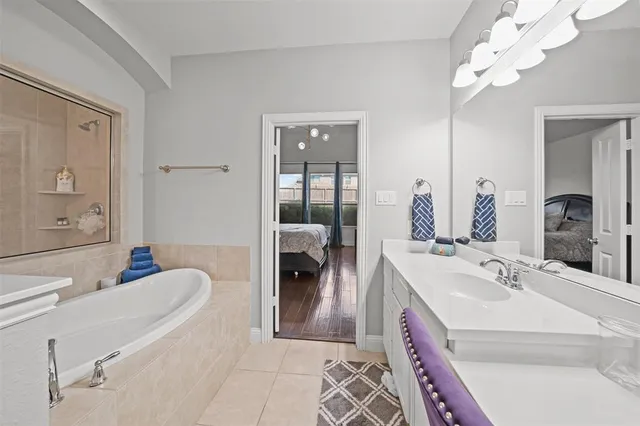 a en suite spacious bathroom with a double vanity sink a large mirror and shower