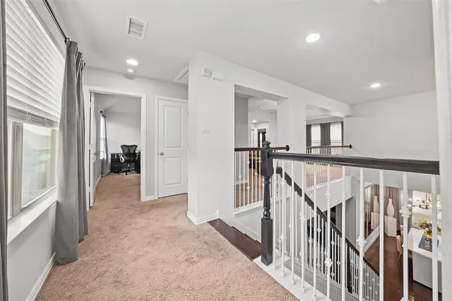 a view of a hallway with wooden floor and windows