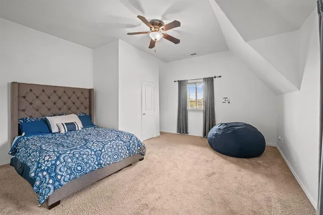 a bedroom with a large bed and a chandelier