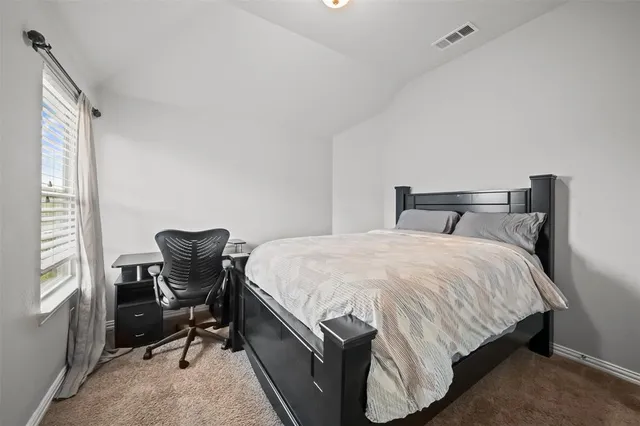 a bedroom with a bed chair and window