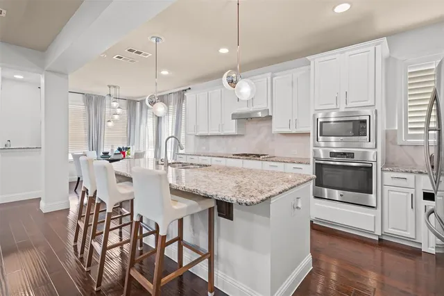 a kitchen with granite countertop a counter space stainless steel appliances and cabinets