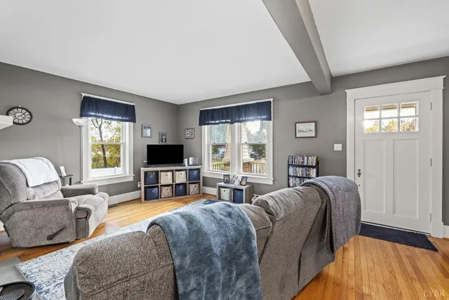 a living room with furniture flat screen tv and a large window