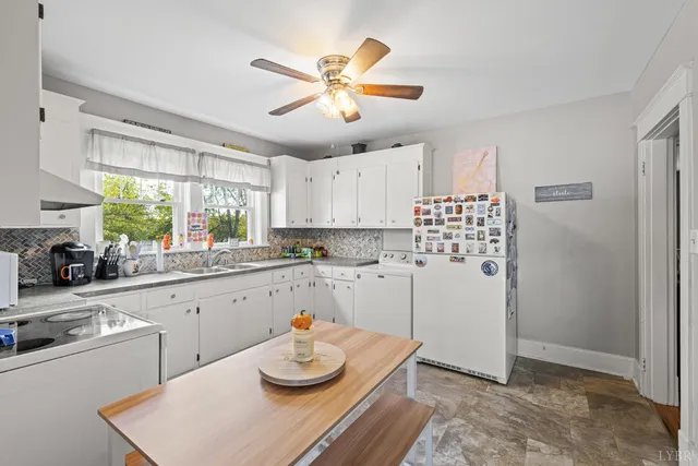 a kitchen with stainless steel appliances kitchen island granite countertop a sink a stove a dining table and chairs
