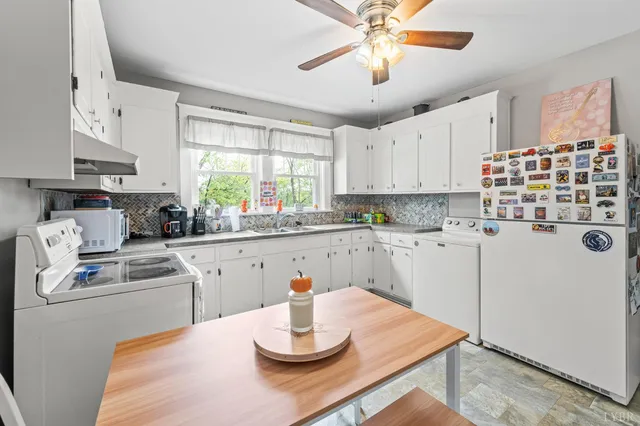 a kitchen with white cabinets and white appliances