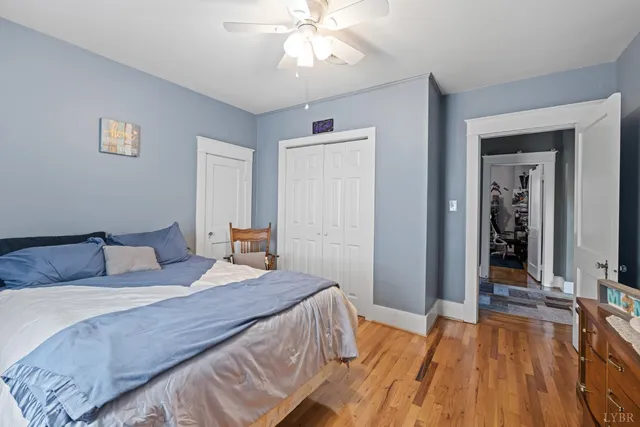 a bedroom with a bed wooden floor and a chandelier