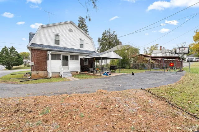 a view of a house with backyard and trees