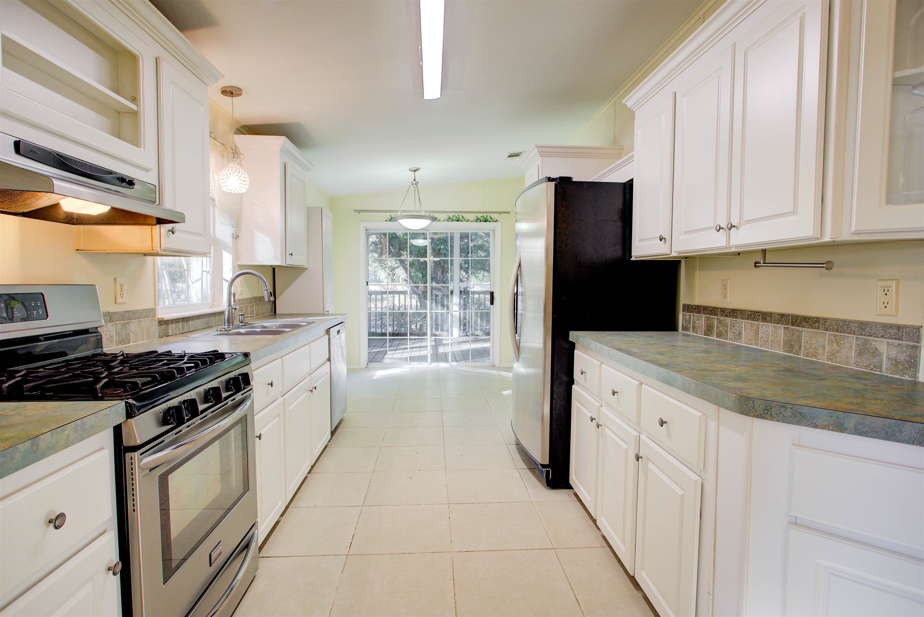 501 Hayley Road St. Augustine, FL 32086 - Photo 13 of 49 Kitchen with stainless steel appliances, pendant lighting, white cabinetry, under cabinet range hood, and light tile patterned floors