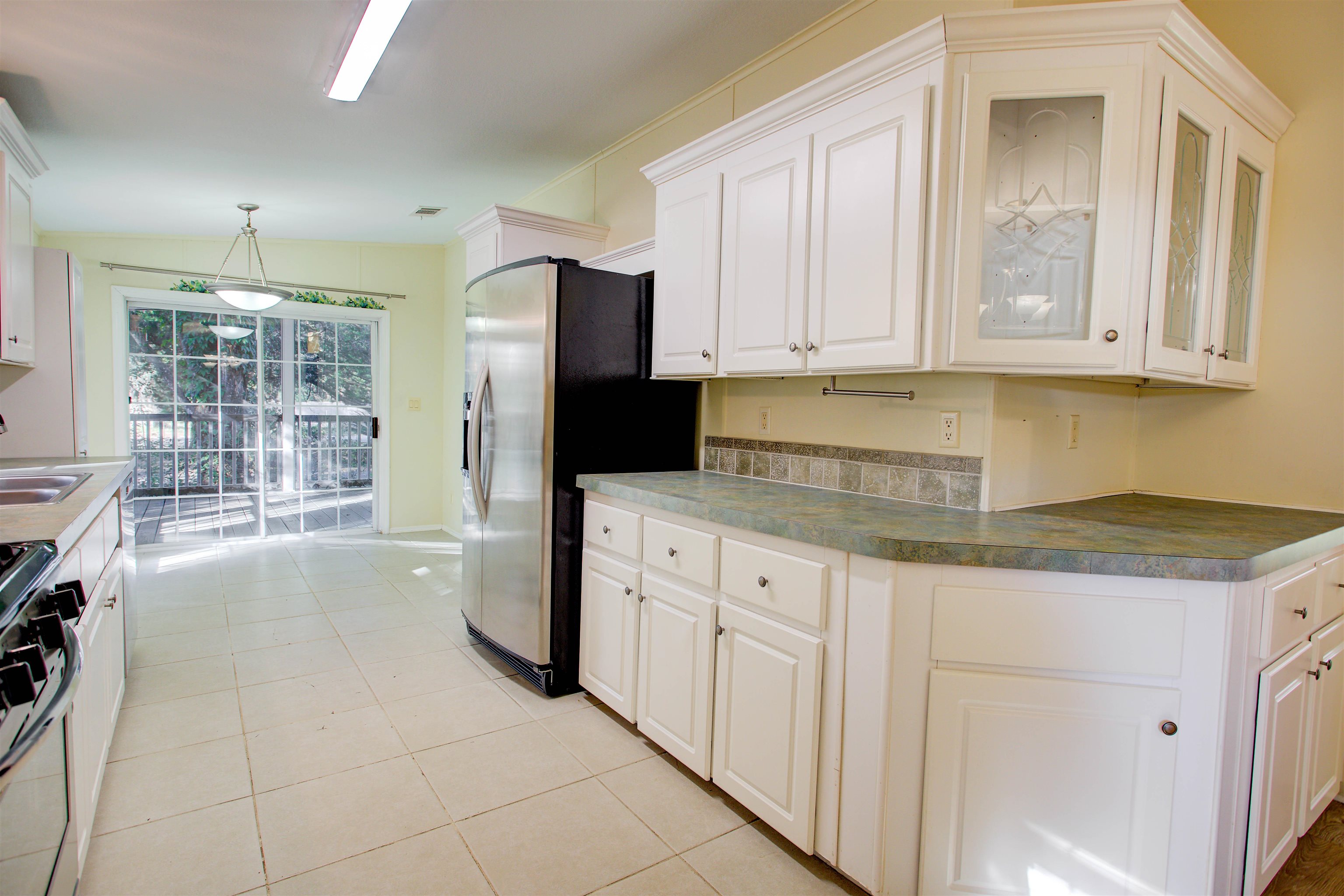 501 Hayley Road St. Augustine, FL 32086 - Photo 14 of 49 Kitchen with white cabinetry, gas range oven, hanging light fixtures, light tile patterned flooring, and stainless steel refrigerator with ice dispenser