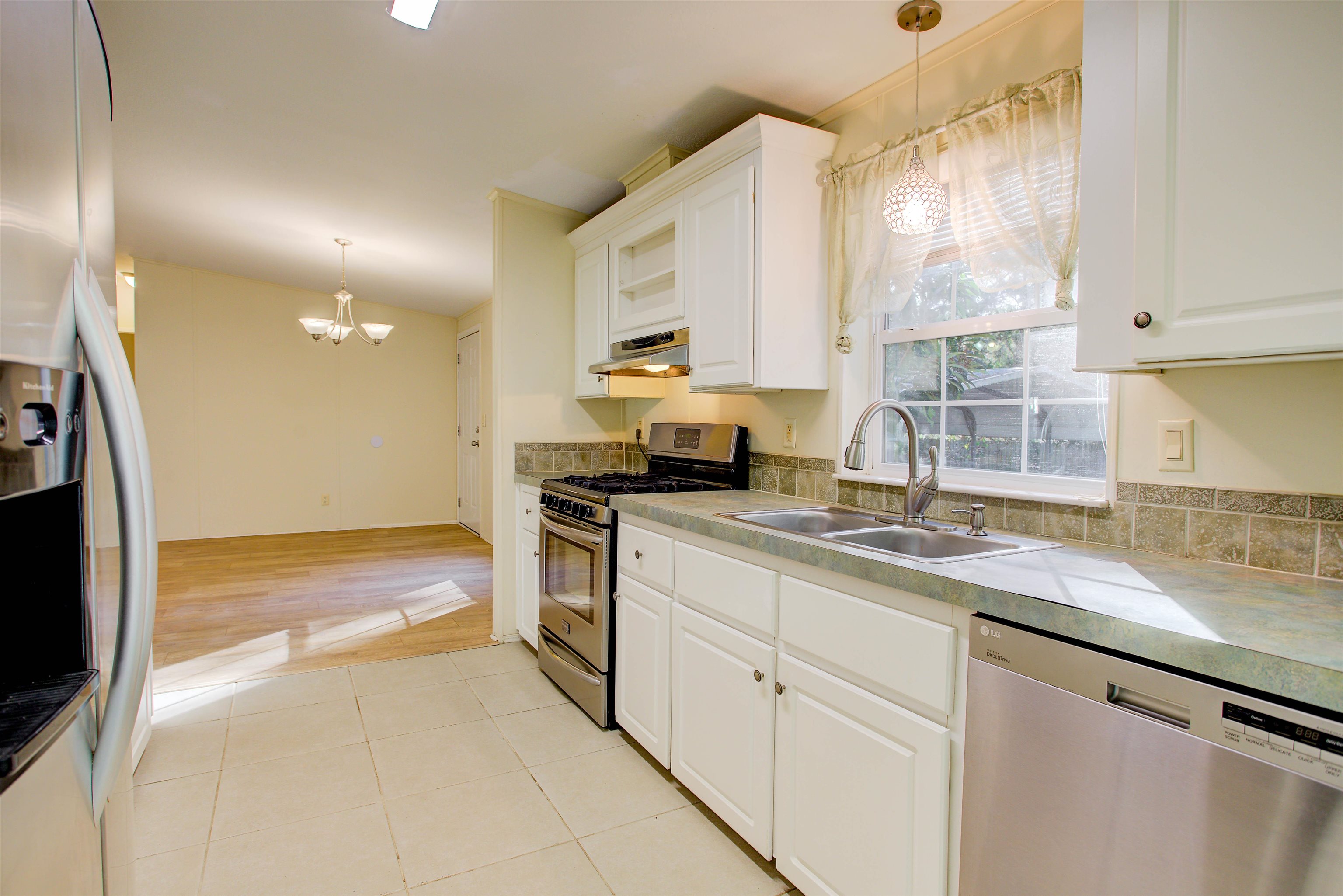 501 Hayley Road St. Augustine, FL 32086 - Photo 15 of 49 Kitchen with stainless steel appliances, white cabinets, pendant lighting, and a chandelier
