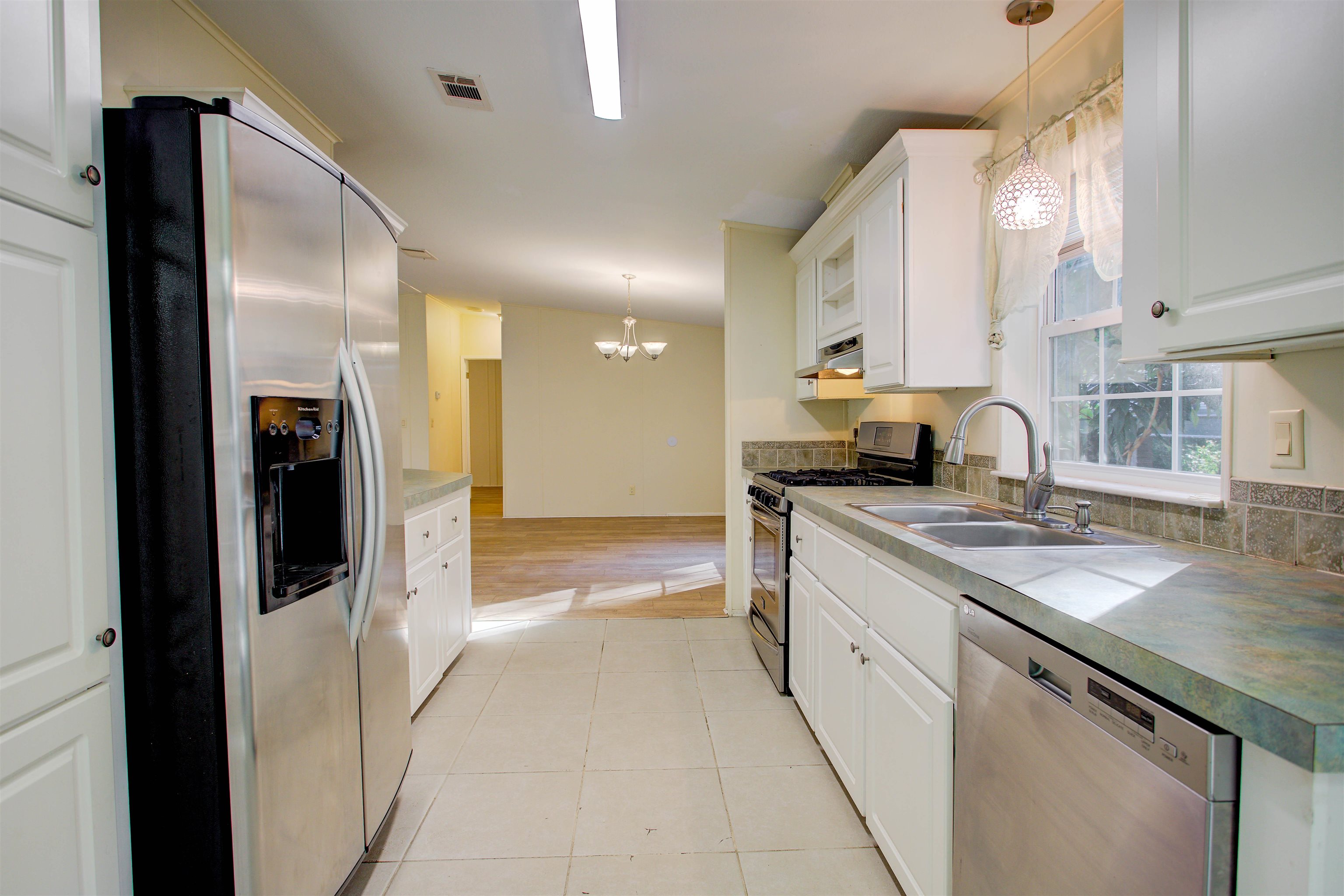 501 Hayley Road St. Augustine, FL 32086 - Photo 16 of 49 Kitchen with decorative light fixtures, white cabinetry, stainless steel appliances, and a chandelier