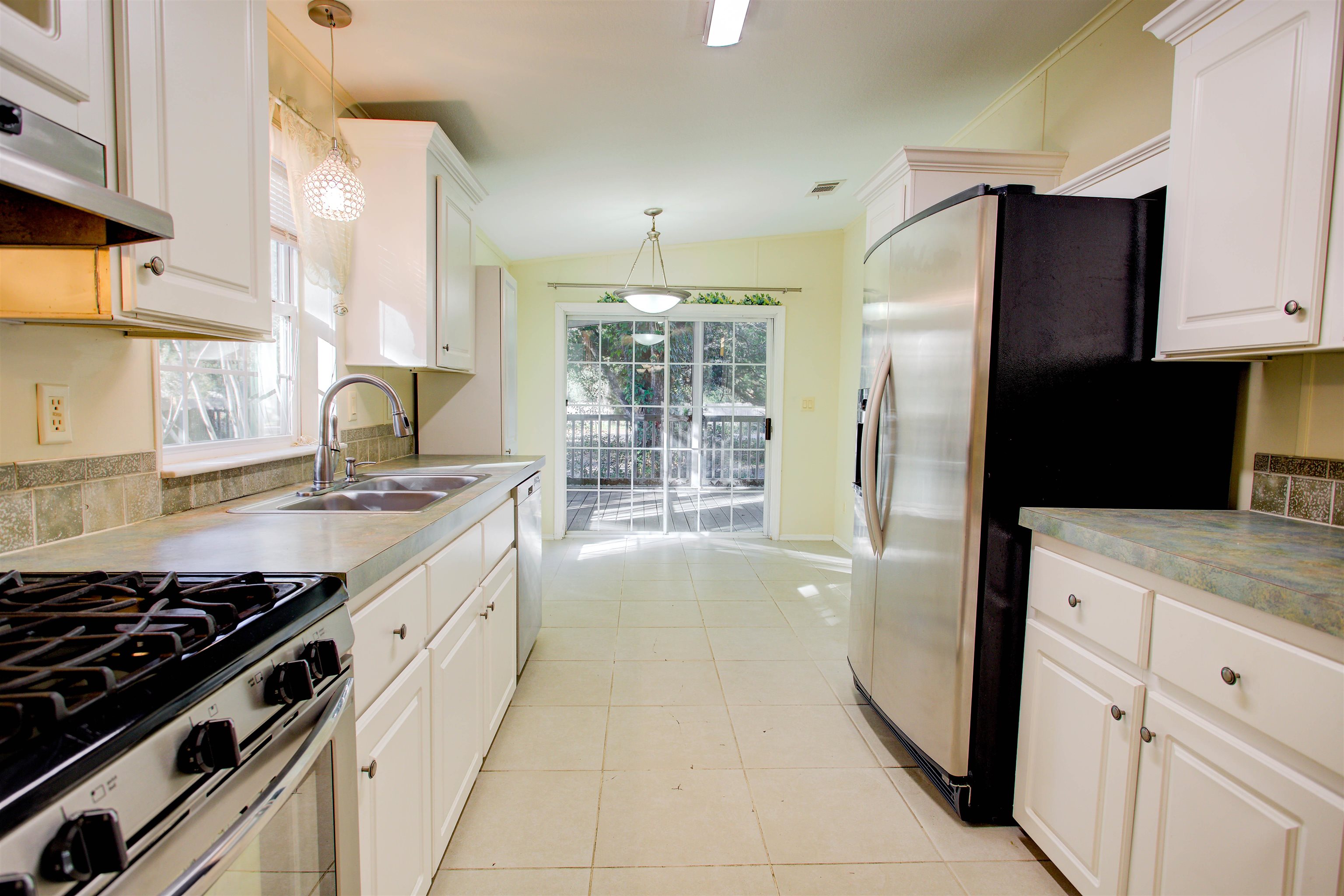 501 Hayley Road St. Augustine, FL 32086 - Photo 18 of 49 Kitchen with pendant lighting, white cabinets, appliances with stainless steel finishes, and under cabinet range hood