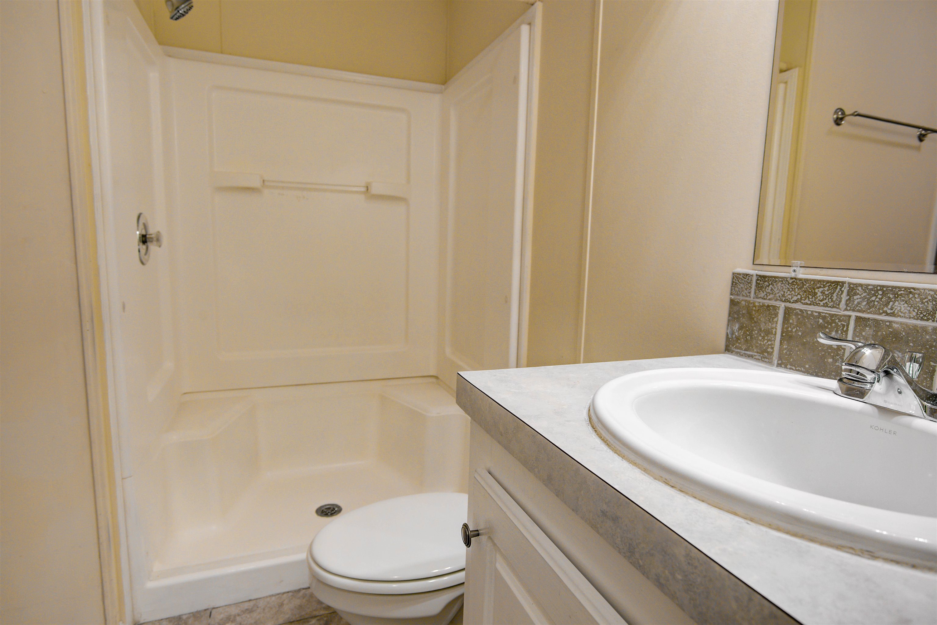 501 Hayley Road St. Augustine, FL 32086 - Photo 31 of 49 Bathroom with vanity, a shower stall, and backsplash