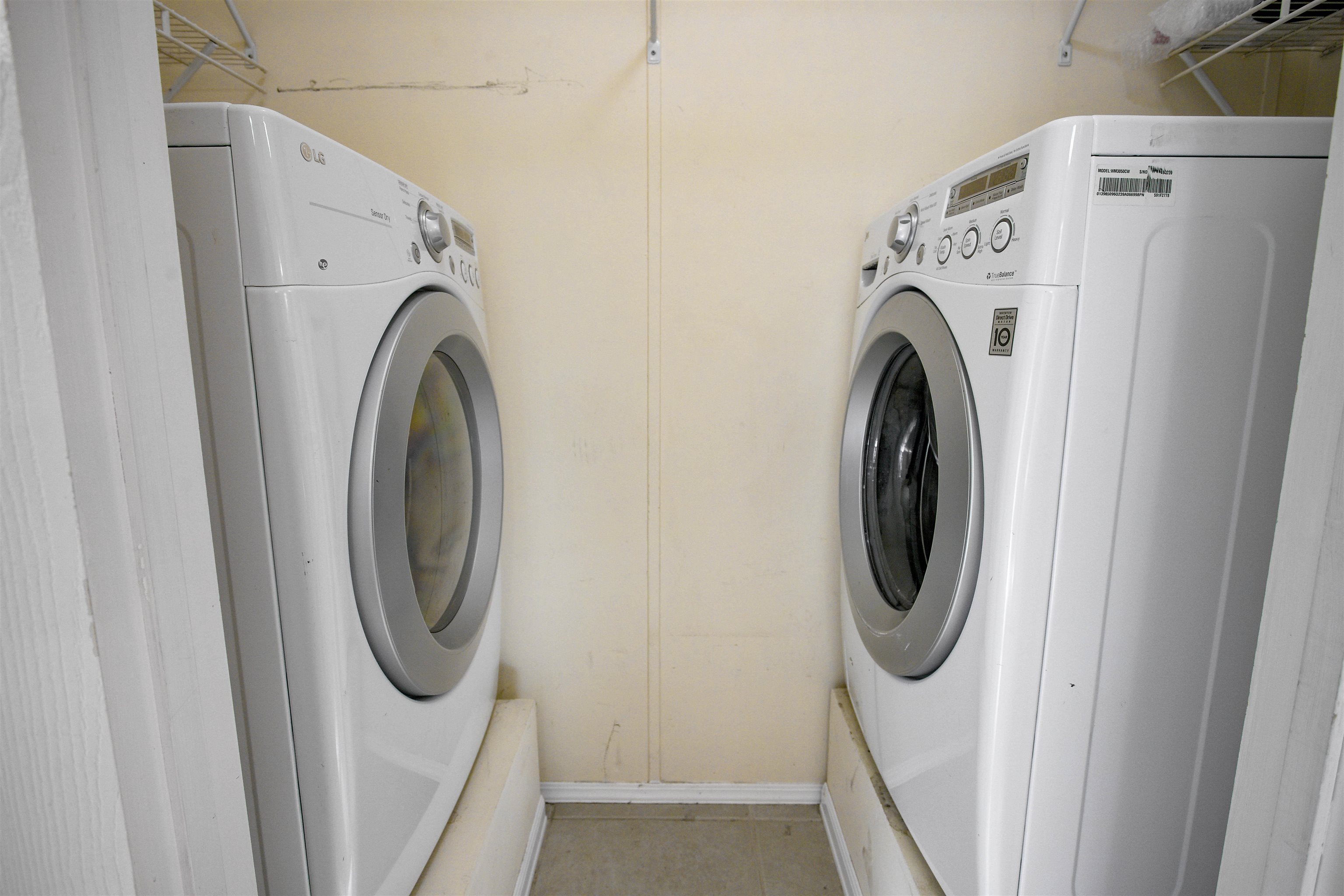 501 Hayley Road St. Augustine, FL 32086 - Photo 32 of 49 Laundry room with washer and clothes dryer and light tile patterned flooring
