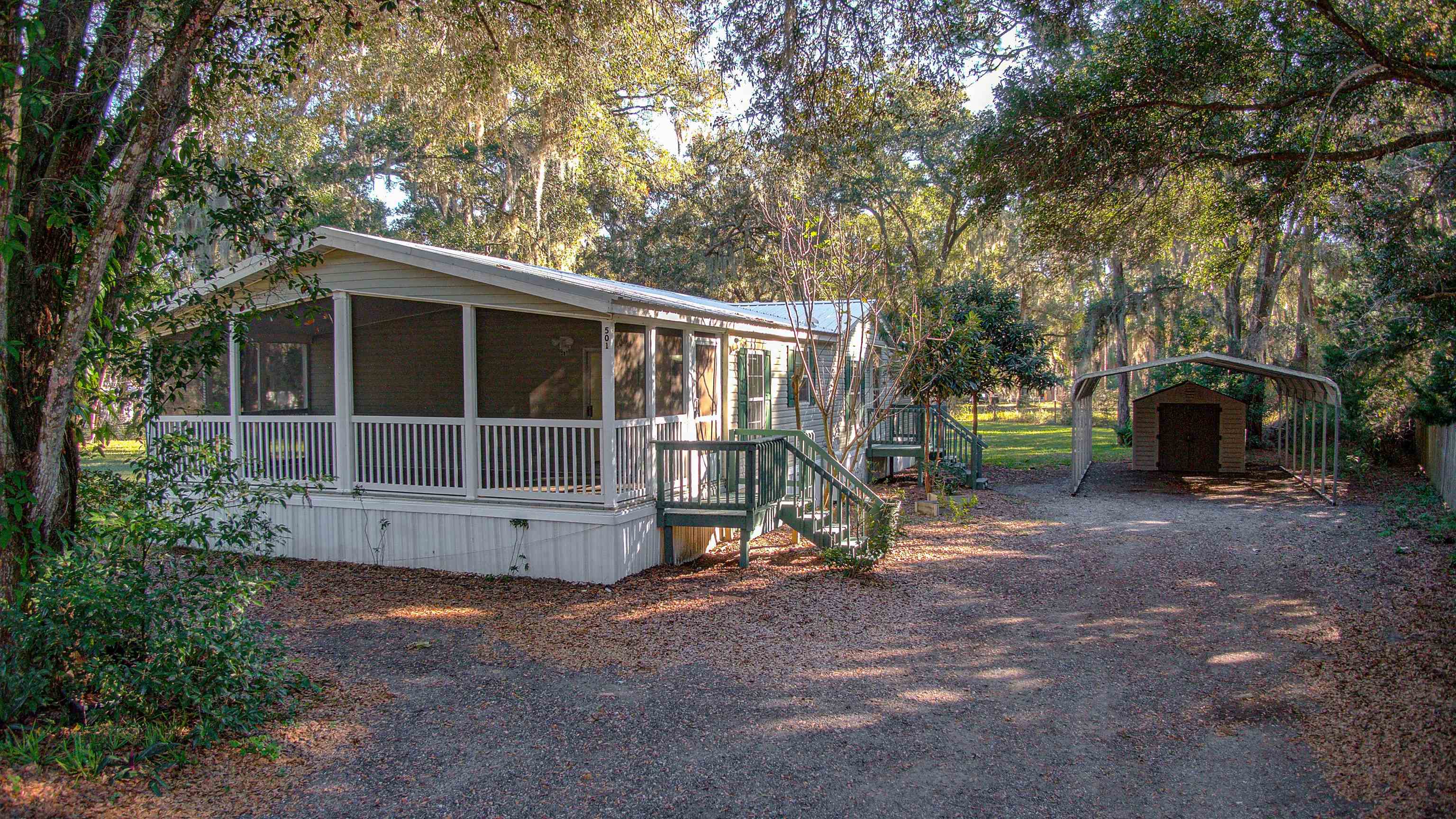 501 Hayley Road St. Augustine, FL 32086 - Photo 36 of 49 View of property exterior with a sunroom, a detached carport, and dirt driveway