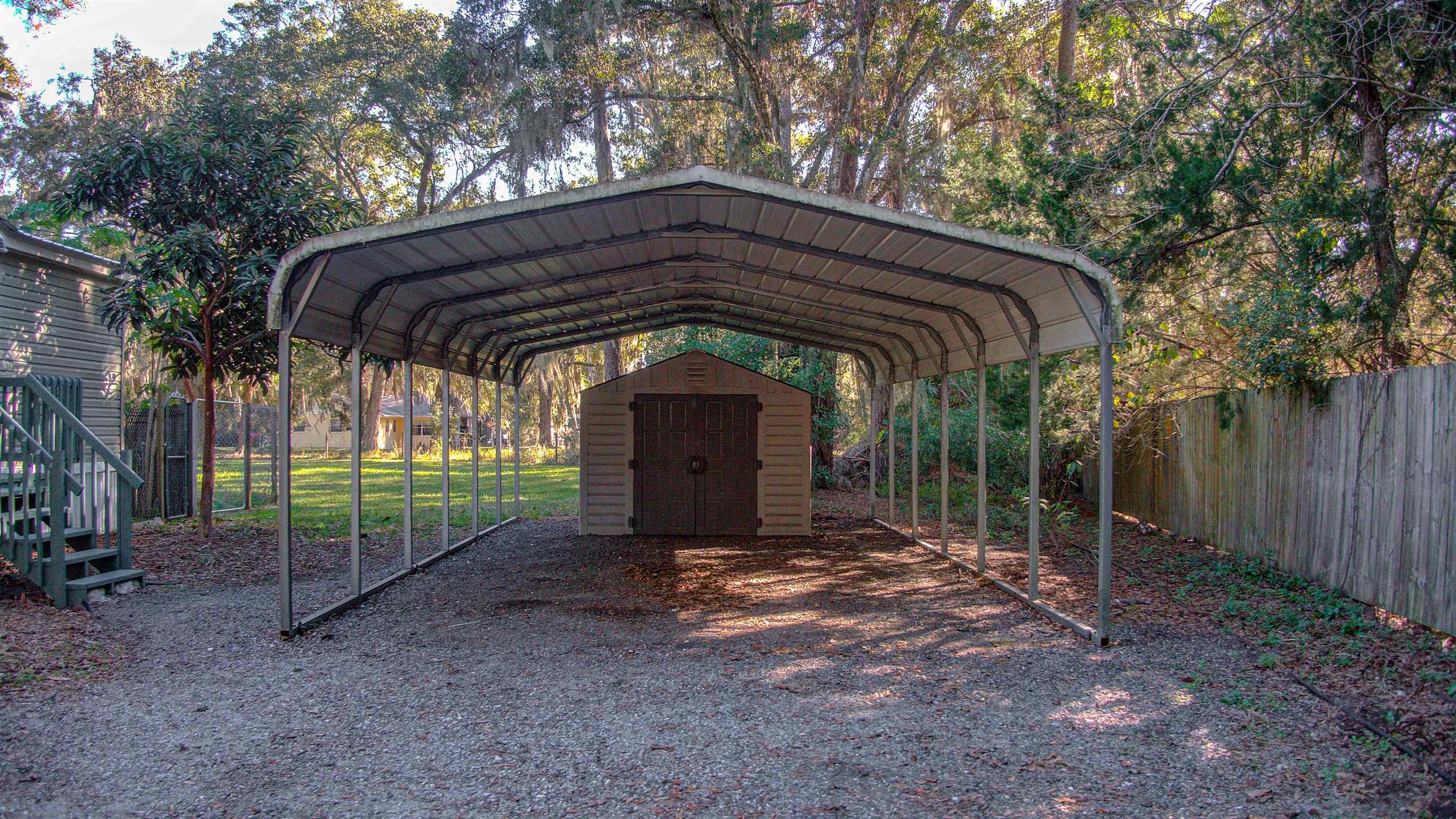 501 Hayley Road St. Augustine, FL 32086 - Photo 38 of 49 View of parking with a detached carport, a storage unit, and driveway