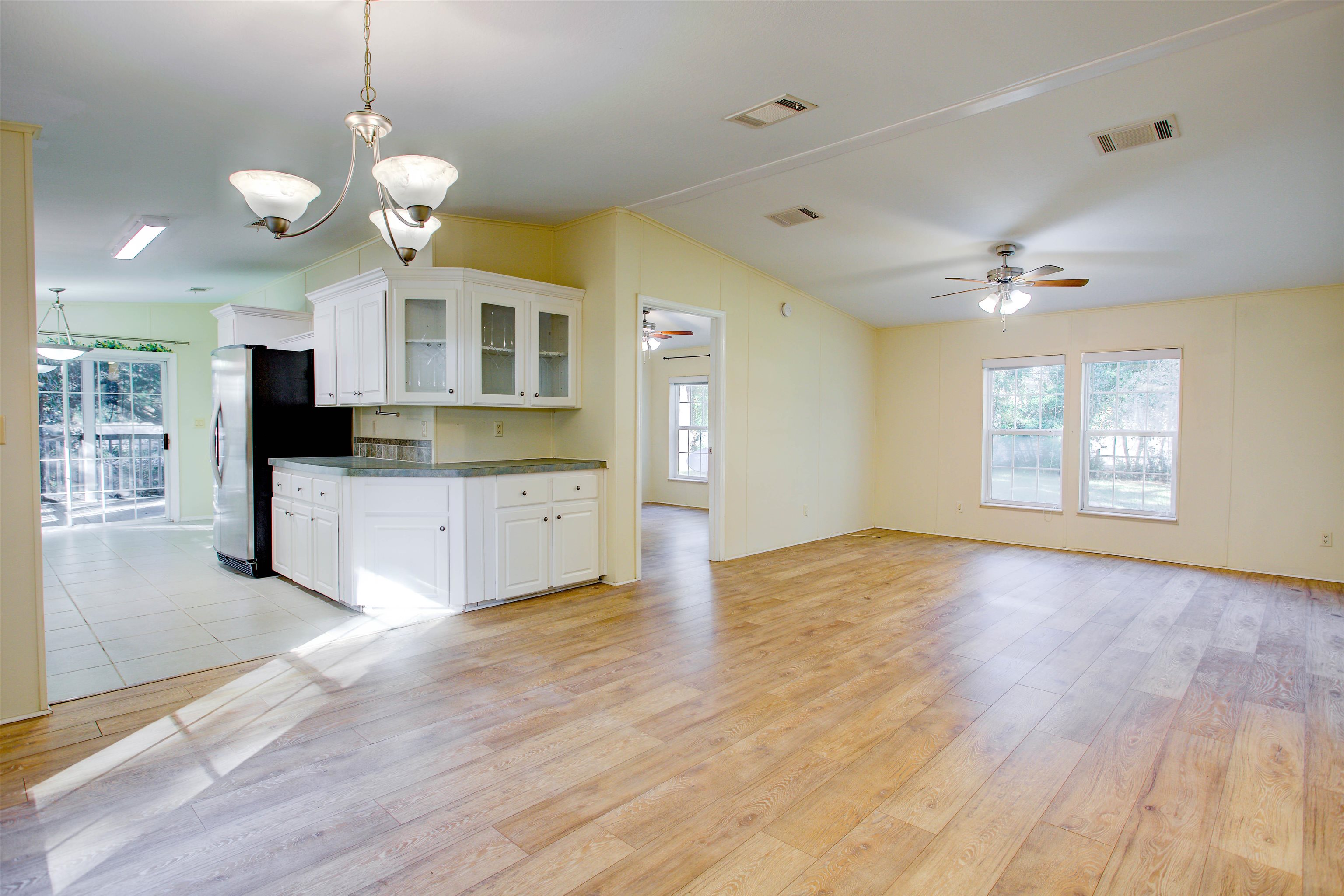 501 Hayley Road St. Augustine, FL 32086 - Photo 6 of 49 Kitchen featuring light wood finished floors, white cabinetry, a ceiling fan, glass insert cabinets, and hanging light fixtures