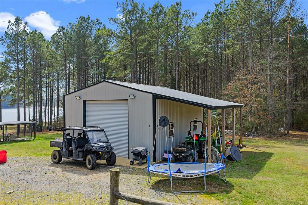 279 Lake Road Plain Dealing, LA 71064 - Photo 15 of 38 a view of a patio with a table and chairs under an umbrella