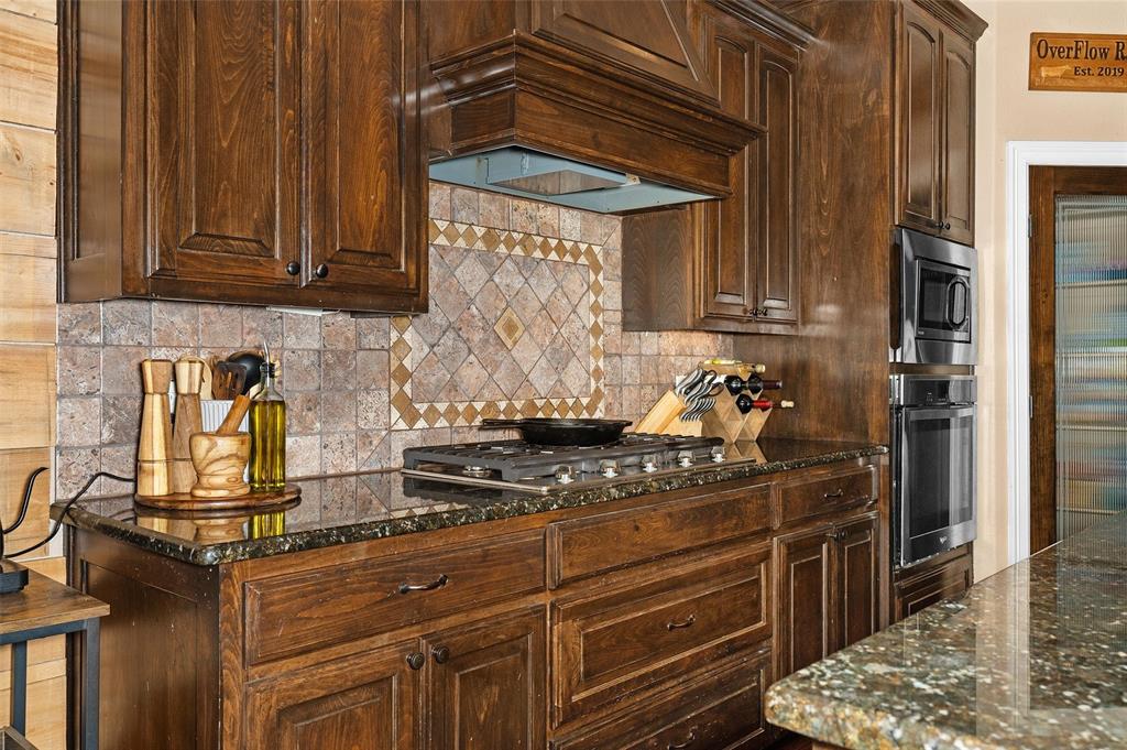 279 Lake Road Plain Dealing, LA 71064 - Photo 22 of 38 a kitchen with granite countertop a stove and cabinets