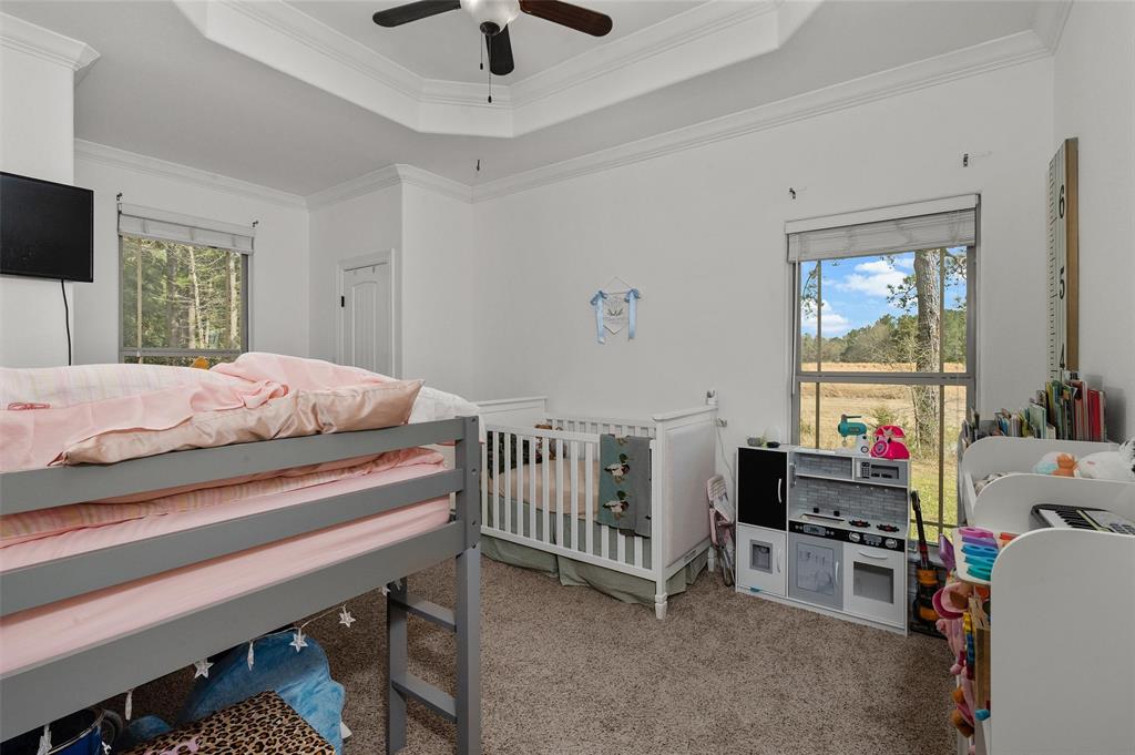 279 Lake Road Plain Dealing, LA 71064 - Photo 29 of 38 a bedroom with a bed and a chandelier