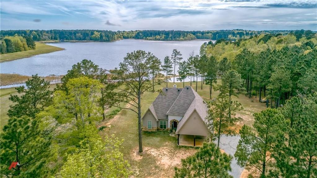 279 Lake Road Plain Dealing, LA 71064 - Photo 3 of 38 an aerial view of a house with green landscape and water view