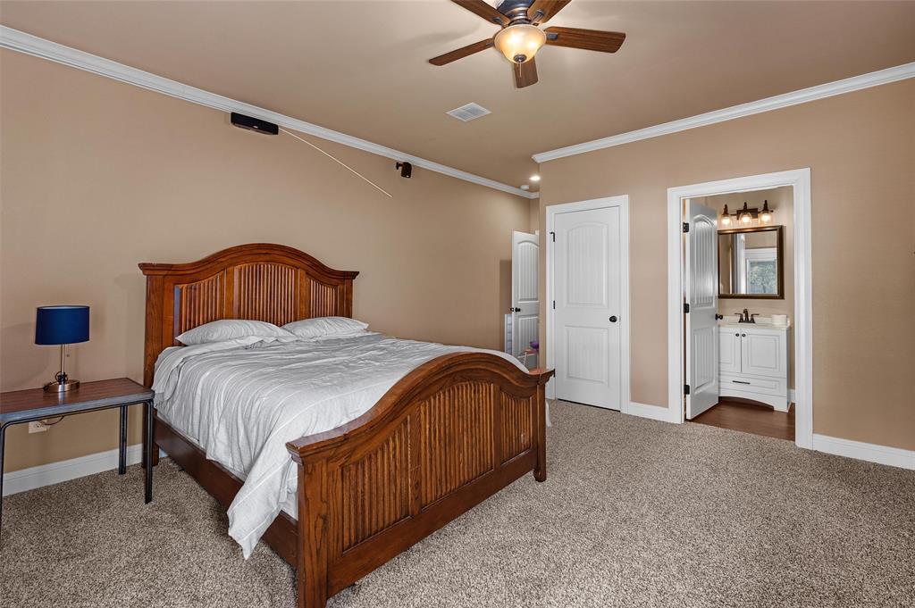 279 Lake Road Plain Dealing, LA 71064 - Photo 33 of 38 a spacious bedroom with a bed and a chandelier