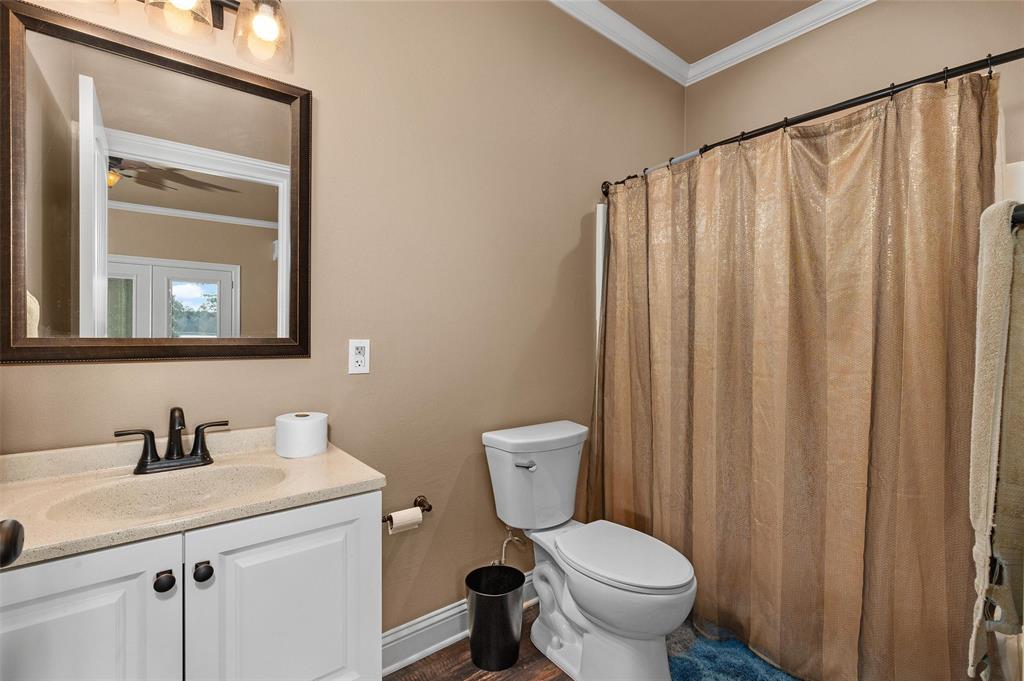 279 Lake Road Plain Dealing, LA 71064 - Photo 34 of 38 a bathroom with a toilet a sink and a mirror