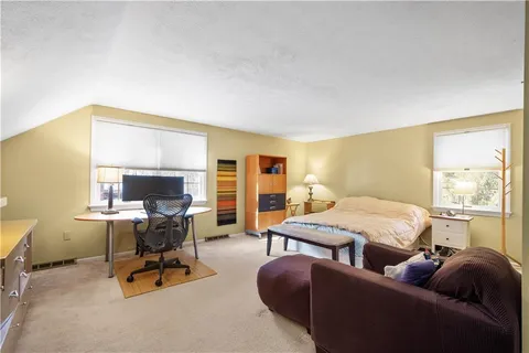 a bedroom with furniture and a large window