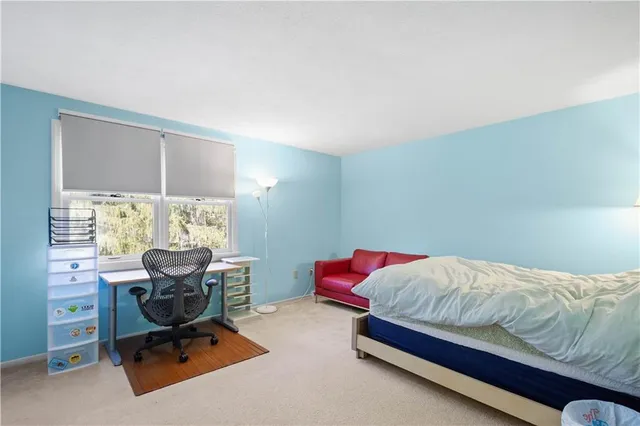 a bedroom with a bed and chair