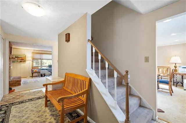 a living room with chairs and stairs