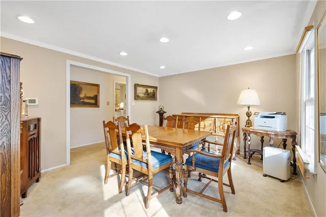 a dining room with furniture and a floor to ceiling window
