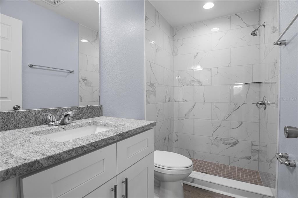 4078 Oak Loop Mulberry, FL 33860 - Photo 11 of 19 a bathroom with a granite countertop sink a toilet and shower