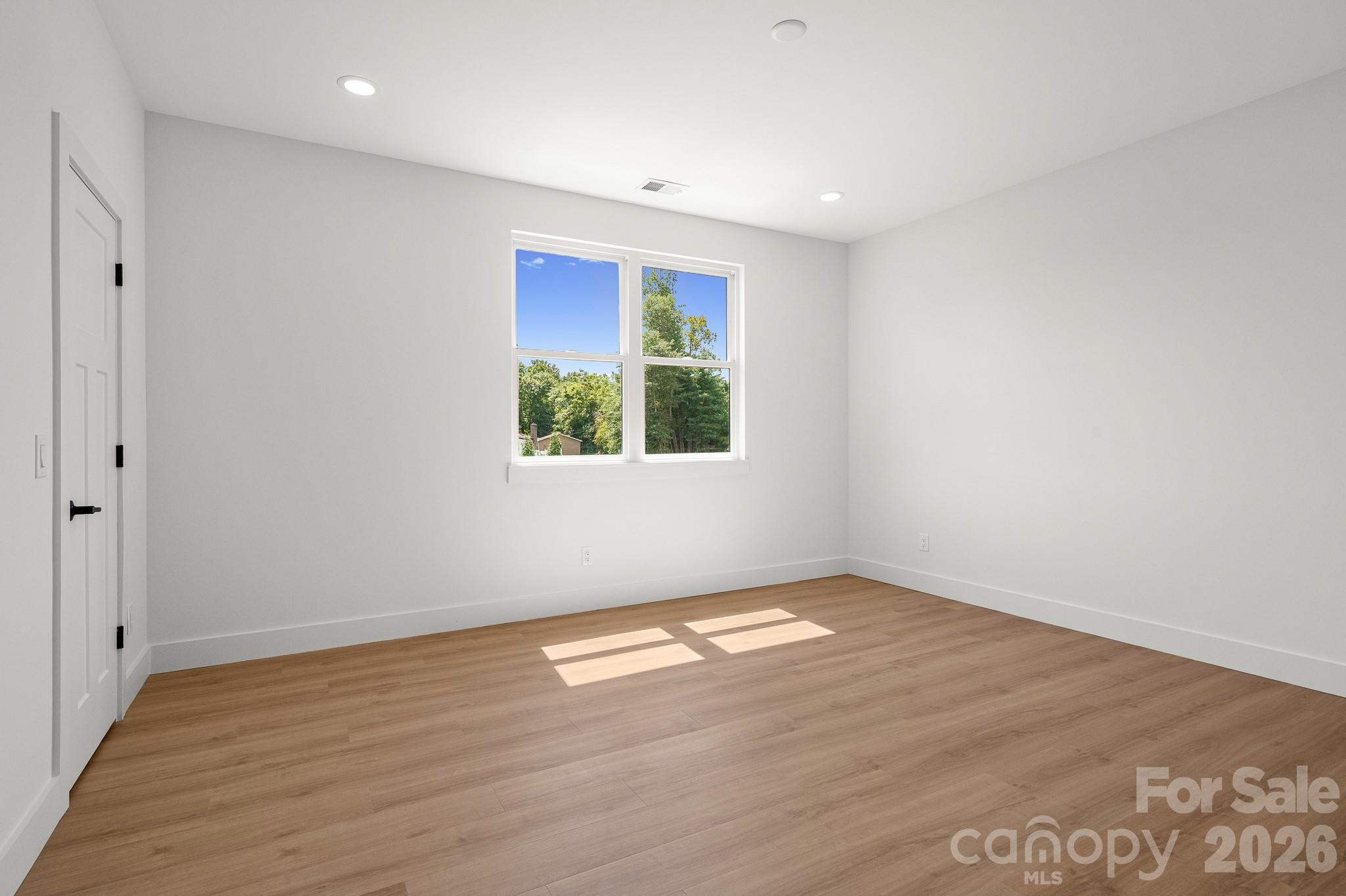 760 New Hope Road Flat Rock, NC 28731 - Photo 26 of 31 an empty room with wooden floor and windows