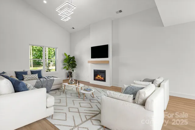 a living room with furniture a fireplace and a flat screen tv