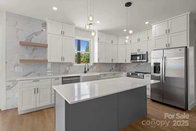 a large kitchen with cabinets a sink and stainless steel appliances