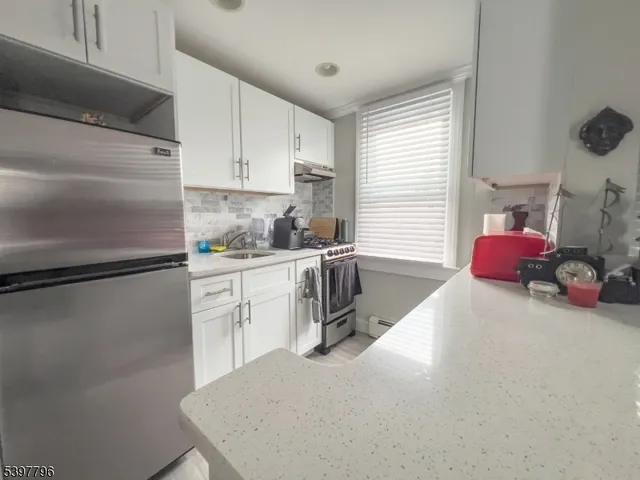 a kitchen with a refrigerator a sink a stove and cabinets