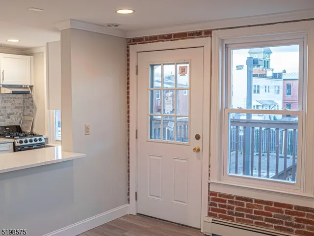a view of a room that has a window and wooden floor