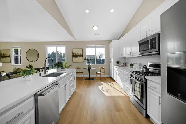 a kitchen with granite countertop a sink stove and cabinets