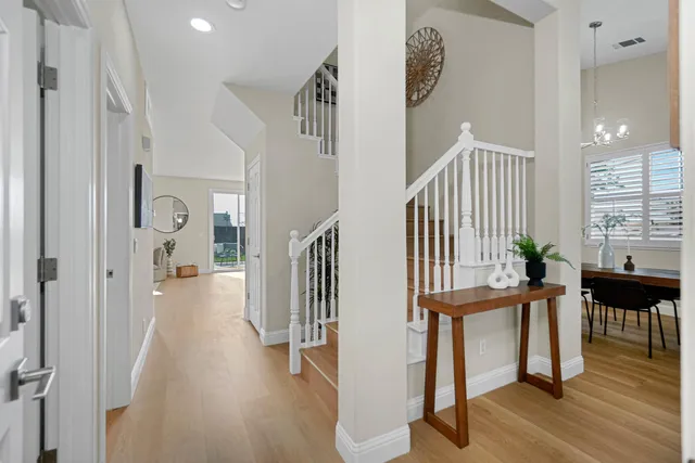 a view of a hallway with wooden floor and windows