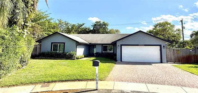 a front view of a house with yard yard and garage