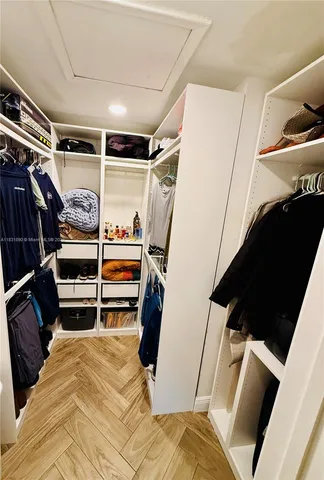 a view of walk in closet with clothes and shoes