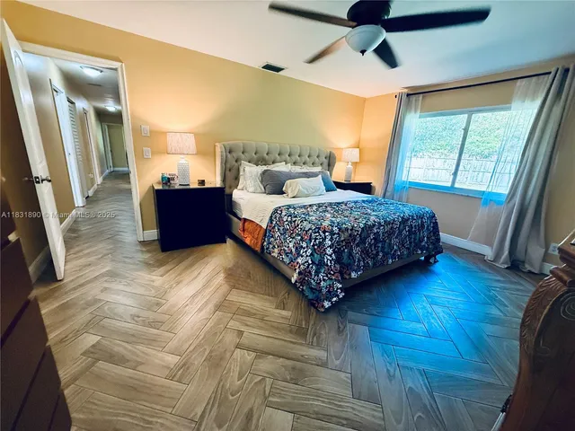 a bedroom with a large bed and a flat tv screen on dresser
