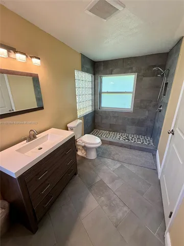 a bathroom with a double vanity sink toilet and mirror