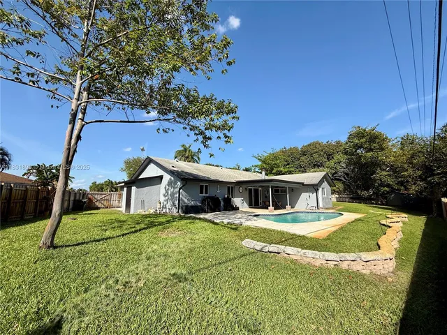 a view of a house with pool and chairs